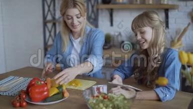妈妈和女儿一起在厨房做饭，看着网上的菜谱，手机平板电脑4K
